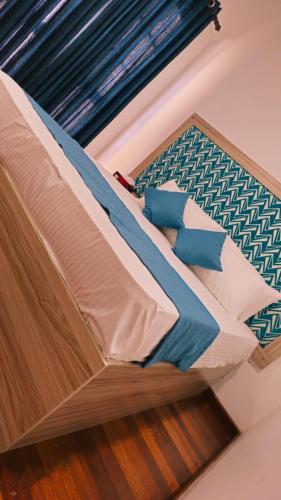 a bed with blue and white sheets and pillows at Samara Villa by Trillium Residencies in Nugegoda