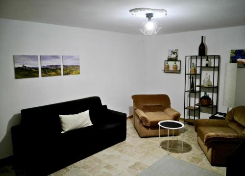 a living room with a couch and a chair at Attico Dogliani Centro LanghExplorer in Dogliani