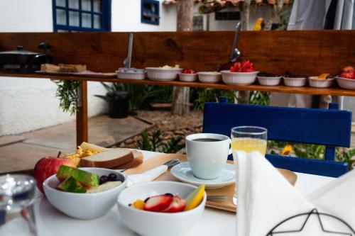 a table with a plate of food and a bowl of fruit at AnaLena Do Mar in Búzios