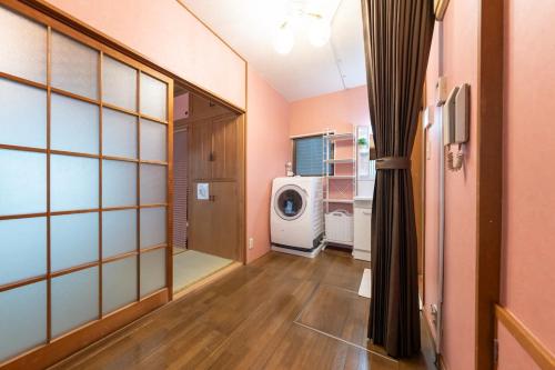 a laundry room with a washing machine in a room at Matsubara Station 2 minutes Shinjuku, Shibuya 15 minutes Pure Japanese style house where you can feel the seasons Maximum 6 people rent a house Quiet house in Tokyo