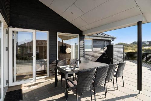 a patio with a table and chairs on a deck at FAN002-Fano-Krinkelkrog-1 in Fanø
