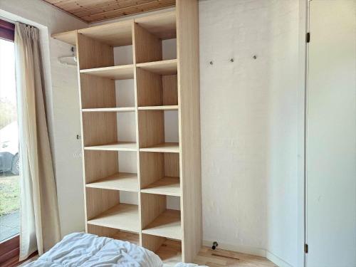 a book shelf in a room with a bed at FAN032-Fano-Skovly-4 in Fanø