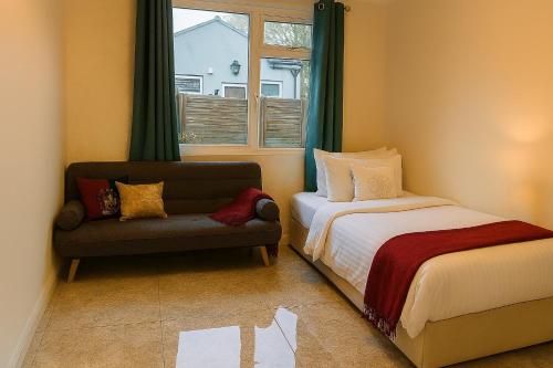 a bedroom with a bed and a couch and a window at Countryside Retreat in Codicote