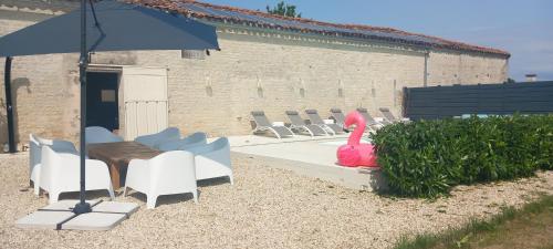 un gruppo di sedie, un tavolo e un ombrellone di Charming countryside retreat a Macqueville