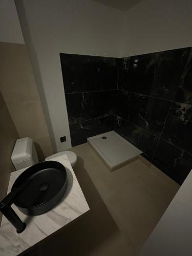 a bathroom with a black toilet and a sink at Aparthotel New Palmarium in Amélie-les-Bains-Palalda