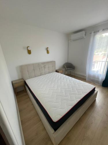 a white bed in a room with a window at Aparthotel New Palmarium in Amélie-les-Bains-Palalda