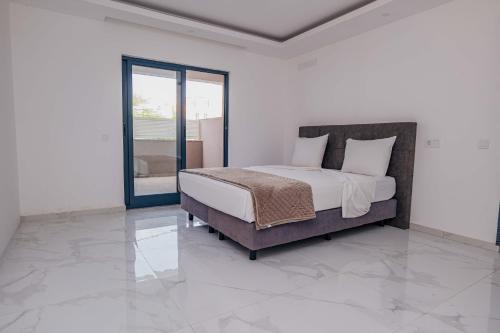 a bedroom with a bed and a glass door at Otro Residence in Praia