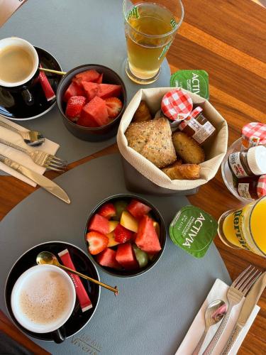 a table with bowls of fruit and cups of coffee at Aparthotel New Palmarium in Amélie-les-Bains-Palalda