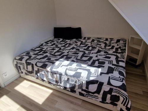 una camera da letto con un letto con un piumone bianco e nero di Maison 3 chambres avec garage, proche de toutes commodités, quartier calme a Chalons en Champagne