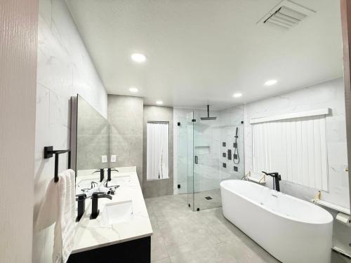a white bathroom with a tub and a sink at Happy Place in Port Saint Lucie