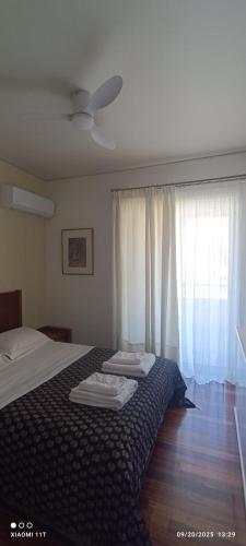 a bedroom with a bed and a window with white curtains at Cozy Room with Sea View in Athens