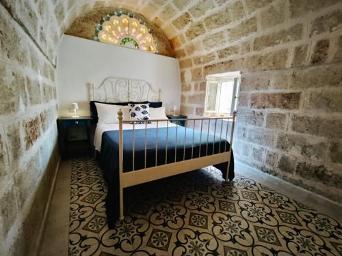 ein Schlafzimmer mit einem Bett in einer Steinmauer in der Unterkunft Antico Gelso in Polignano a Mare