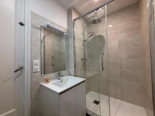 a bathroom with a sink and a glass shower at Chez Ali - T3 central and calm in Creil