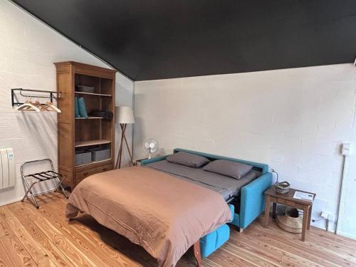 een slaapkamer met een blauw bed in een kamer bij Logement avec terrasse in Toulouse