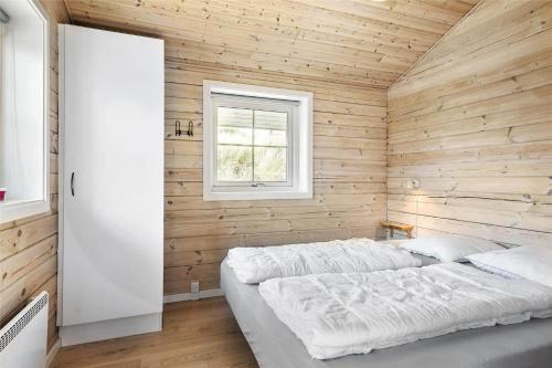 a bedroom with a bed in a wooden wall at 128-Ringkobing-Troldedalen-18 in Nørby
