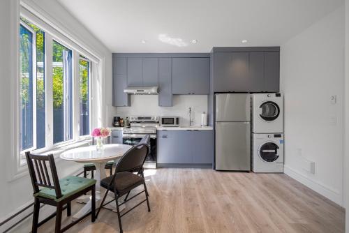 a kitchen with a table and chairs and a refrigerator at Dunbar Brand-new laneway house in Vancouver