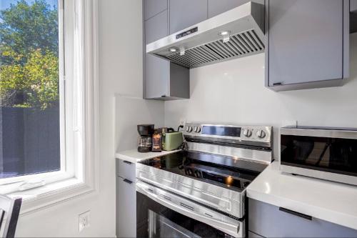 a kitchen with a stove top oven next to a window at Dunbar Brand-new laneway house in Vancouver