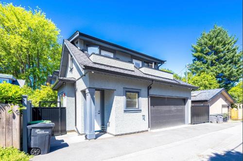 a house with a garage on a street at Dunbar Brand-new laneway house in Vancouver