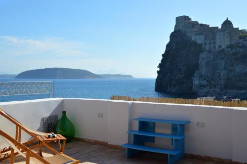 a balcony with a blue stool and a view of the ocean at Terrazza Aragonese in Ischia Town