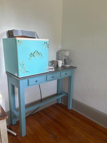 Una mesa azul en una habitación con una mesa con tazas. en Historical downtown Lind House Studio, en Pensacola