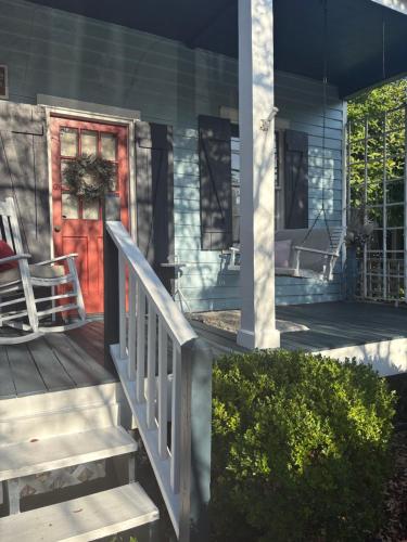 a front porch with a red door and stairs at Historical downtown Lind House Studio in Pensacola
