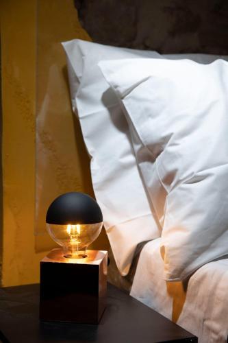 a nightstand with a ball on a table next to a bed at Rustico di charme in Fiano Romano