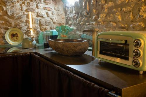 una encimera de cocina con microondas y un tazón. en Rustico di charme, en Fiano Romano