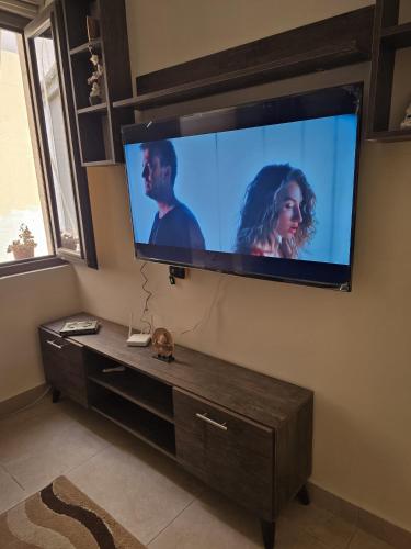 a flat screen tv hanging on a wall at Masa sharing home private rooms and private bathroom in Amman