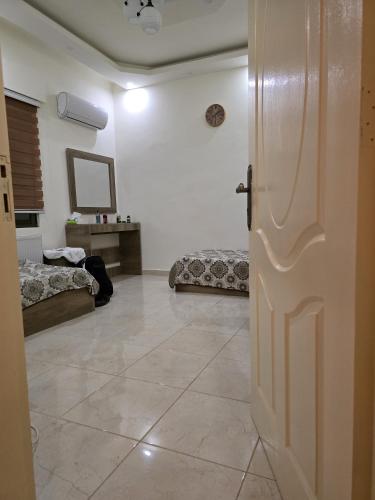 a room with a door and a room with two beds at Masa sharing home private rooms and private bathroom in Amman