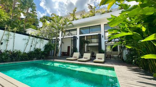 a villa with a swimming pool and a house at Canggu Villa - 7BR Private Cook, Pool, Rooftop Cinema in Canggu