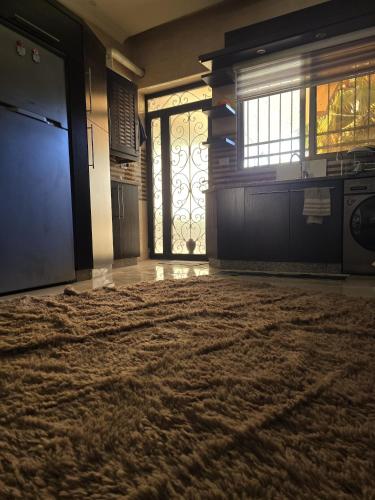 a living room with a large rug in front of a door at Masa sharing home private rooms and private bathroom in Amman