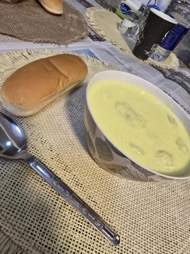 a bowl of soup next to a loaf of bread and a spoon at Masa sharing home private rooms and private bathroom in Amman