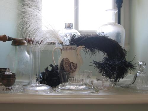 a shelf with glass vases and plants on it at Château d’Orion in Orion