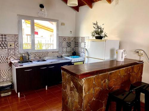 a kitchen with a white refrigerator and a window at Casa Los Huemules in El Chalten