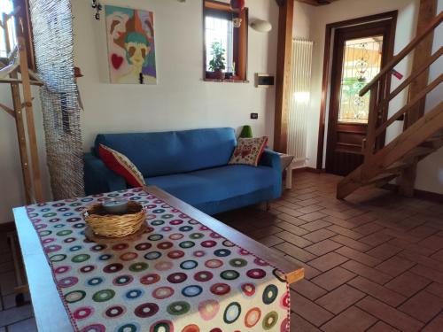 a living room with a blue couch and a table at "La casetta" indipendente, con ampio spazio verde in Fontechiari