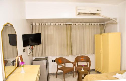 a living room with two chairs and a television at Oscar Hotel Aswan in Aswan