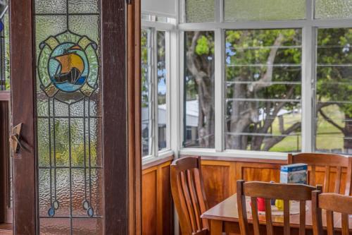 a dining room with a table and chairs and windows at East of Eden in Eden