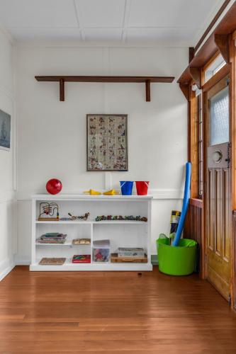 a living room with white shelves and wood floors at East of Eden in Eden