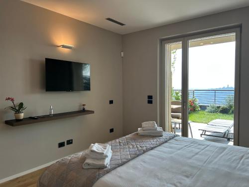 ein Schlafzimmer mit einem großen Bett und einem Fernseher an der Wand in der Unterkunft Exclusive flat on Lake Como with panoramic views in Como