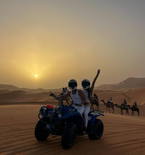 two people riding on a four wheeler in the desert at Sahara dream luxury in Merzouga
