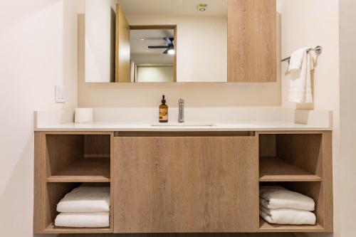 a bathroom with a sink and a mirror at Luxury Pedregal Condo - Views, Pool & Concierge in Cabo San Lucas