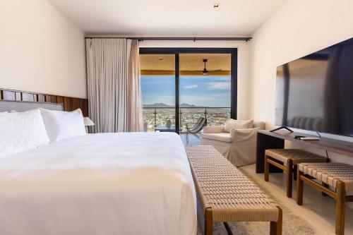 a bedroom with a large bed and a large window at Luxury Pedregal Condo - Views, Pool & Concierge in Cabo San Lucas