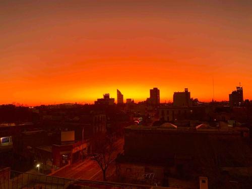 a city skyline with a sunset in the background at Charming flat with big private Terrace in Montevideo