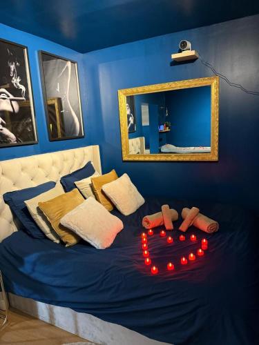 a blue bedroom with a bed with red lights on it at L'instant Suspendu-Studio Jacuzzi Terrasse Plages in Saint-Aunès