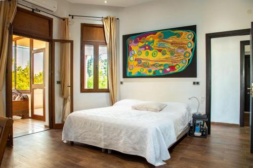 a bedroom with a bed and a painting on the wall at La maison des ruines in Tunis