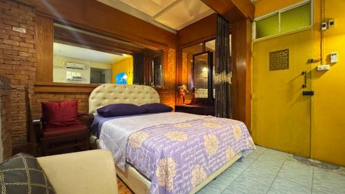 een slaapkamer met een bed en een stoel bij Café de Baan Raow in Bangkok