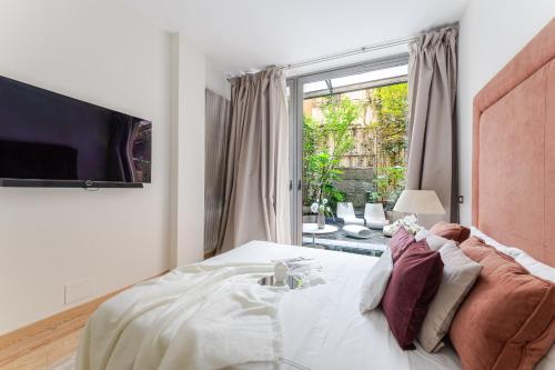 a bedroom with a bed and a large window at BreraPrivata - appartamento con giardino e spa ad uso esclusivo - Milano in Milan