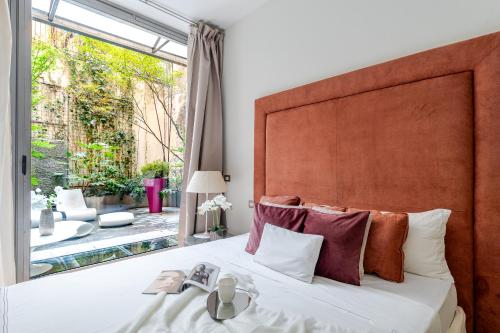 a bedroom with a large bed and a large window at BreraPrivata - appartamento con giardino e spa ad uso esclusivo - Milano in Milan