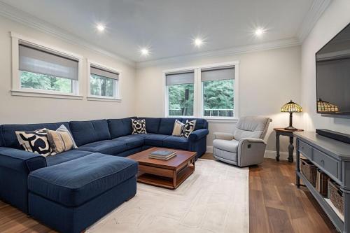 a living room with a blue couch and a tv at Breckenridge Alpine Residence in Breckenridge