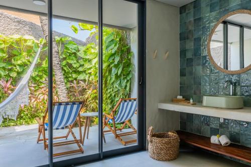 a bathroom with two chairs and a mirror at Saline Taíba Boutique Beach Hotel in Taíba